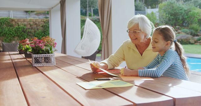 Grandmother and Granddaughter Drawing Together on Sunny Patio - Download Free Stock Images Pikwizard.com