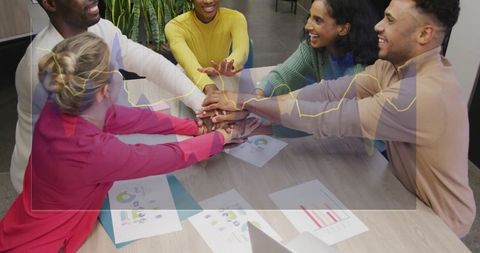 Diverse team stacking hands showing unity and corporate success