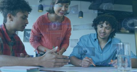 Team collaborating around table with holographic data overlays in modern coworking space