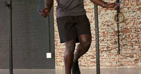 Fit man jump roping in urban gym for cardio exercise