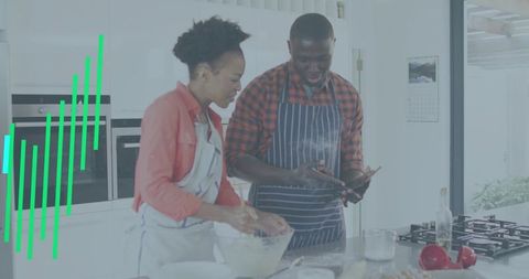 Black couple cooking together in bright modern kitchen mixing batter and using smartphone