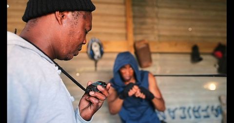 Trainer Timing Boxer with Stopwatch in Fitness Studio