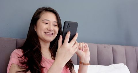 Relaxed Woman Smiling While Texting at Home