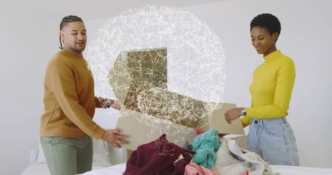 Couple unpacking and sorting clothes with futuristic neural network hologram over bed
