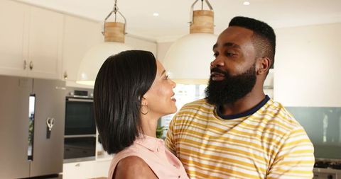 Diverse Couple Sharing Tender Moment in Modern Kitchen