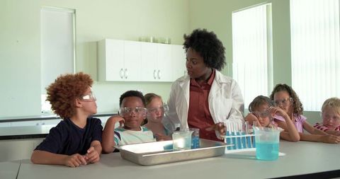 African american teacher leading hands-on science experiment with curious students