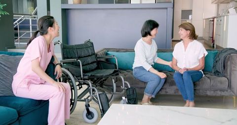 Senior Women Engaging with Nurse in Modern Living Room