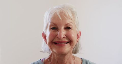Smiling Senior Woman in Light Blue Blouse with Casual Elegance