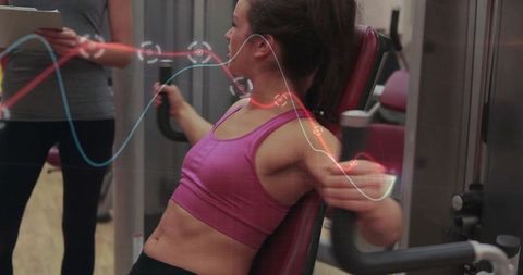 Female athlete performing chest fly on pec deck with digital fitness analytics