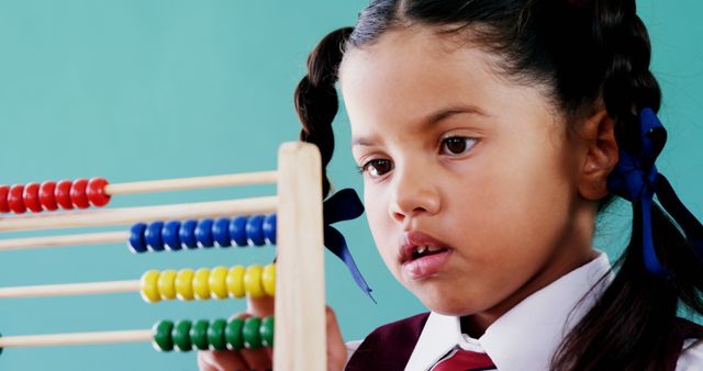 Cute little girl counting on abacus in classroom - Download Free Stock Photos Pikwizard.com