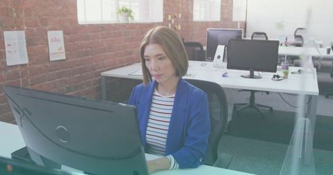 Focused Businesswoman Working at Large Monitor in Bright Office