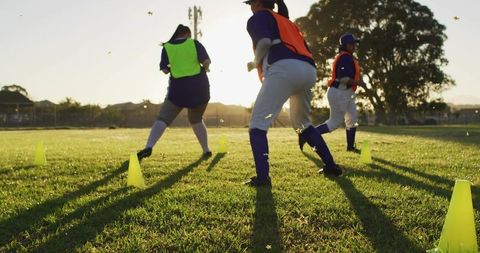 Women running agility drill at sunset on grass field