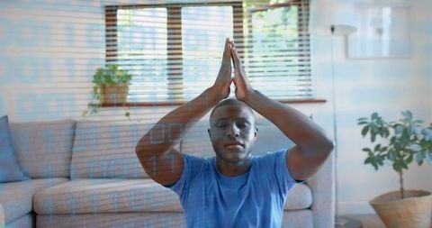 Meditating black man practicing mindfulness at home with digital wellness overlay