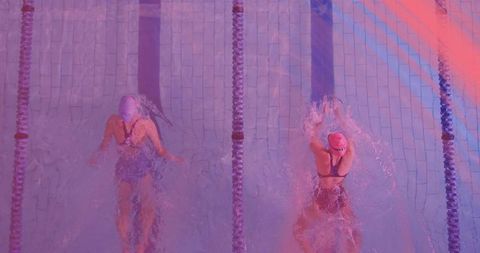 Competitive Swimmers Racing in Pool Event with Vibrant Lighting