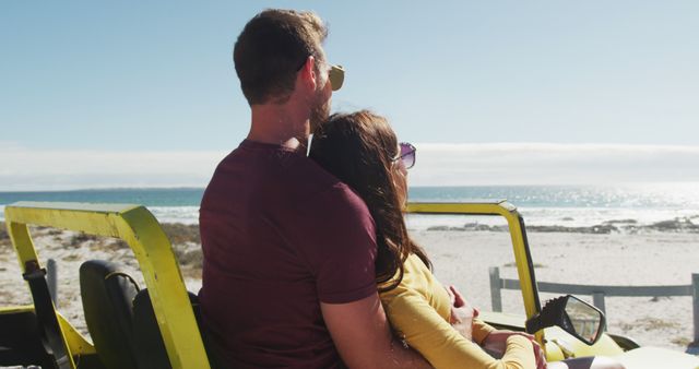 Happy caucasian couple sitting in beach buggy by the sea talking. beach stop off on summer holiday road trip.