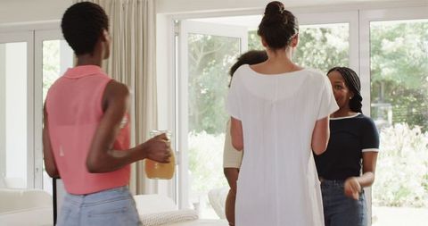 Diverse Friends Dancing and Laughing in Living Room Gathering