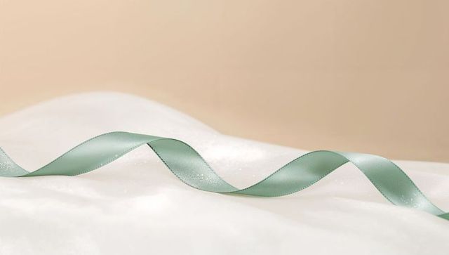 Pale Green Satin Ribbon Creating Curving S-Wave on Soft White Fabric with Glitter, Pastel