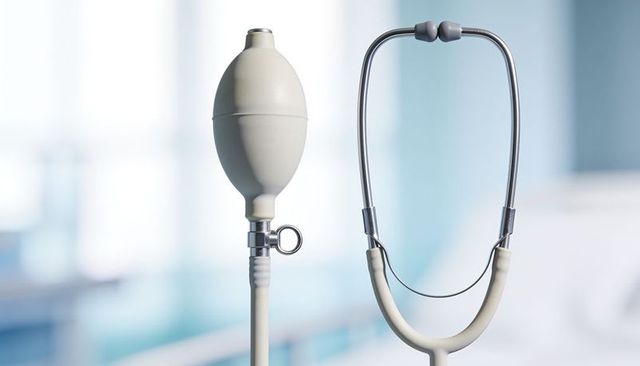 Closeup clinical instruments showing white bulb syringe and stethoscope on exam table