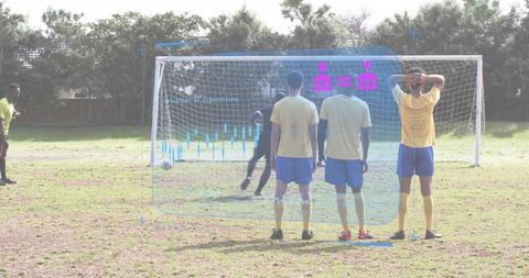 Goalkeeper diving left while defensive wall bracing with hud analytics overlay on grass pitch