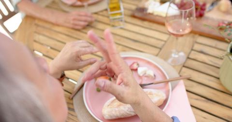 Senior Friends Enjoying Outdoor Meal in Sunlit Setting