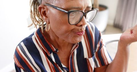 Senior african american woman drinking water indoors