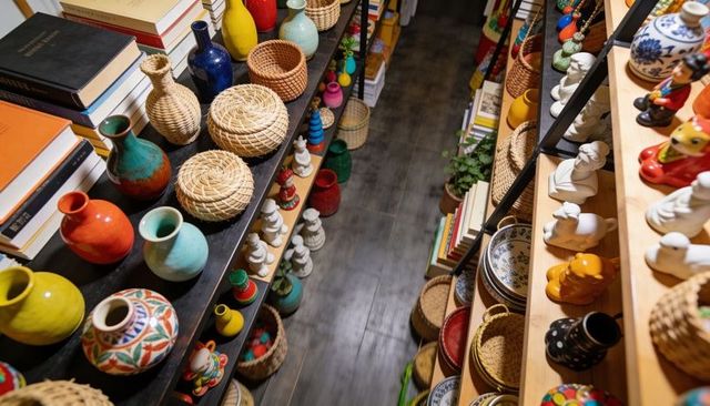 Colorful handmade pottery and woven baskets displaying boutique shop shelves with figurines