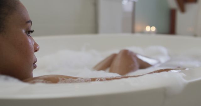 Woman relaxing in bubble bath at home. Represents self-care, wellness, and relaxation themes. Useful for content related to spa experiences, self-care routines, mental health breaks, and home relaxation ideas.