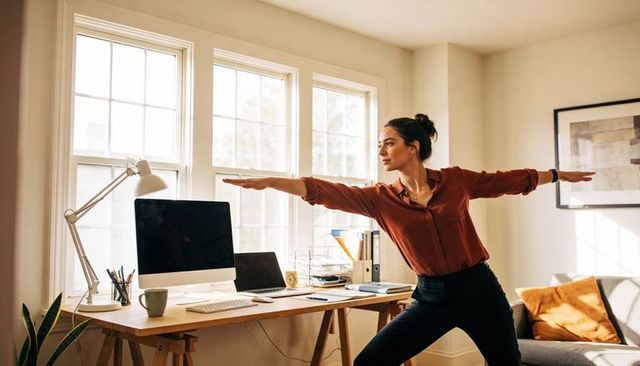 Midday desk yoga stretching in sunlit home office for wellness and productivity