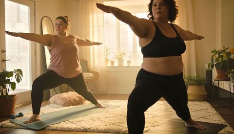 Plus-size women practicing yoga in sunlit living room promoting body positivity and wellness