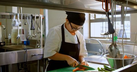 Female Chef Slicing Vegetables in Restaurant Kitchen Atmosphere