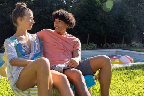 Young couple relaxing poolside on sunny day, summer romance and backyard leisure