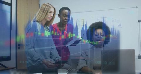 Diverse team analyzing financial charts on laptop during collaborative office meeting