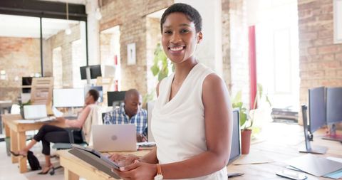 Joyful Businesswoman Using Tablet in Modern Office Space