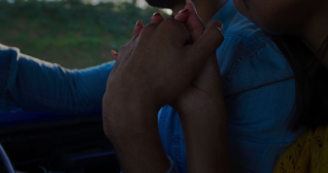 African American couple holding hands in a car, with copy space. Their interlocked fingers symbolize connection and support during a journey.