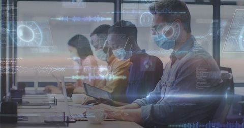 Diverse colleagues wearing masks working with data technology in office