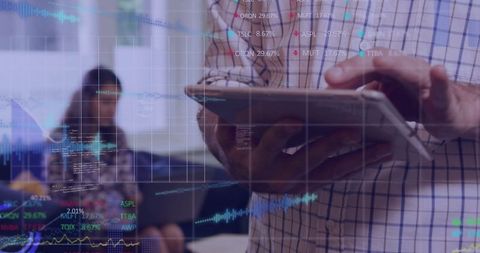 Manager Reviews Digital Charts on Tablet in Office Environment