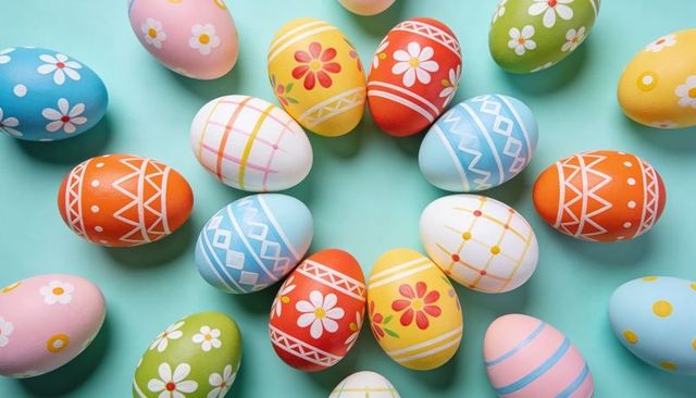 Colorful decorated Easter eggs forming circular wreath on mint-turquoise tabletop
