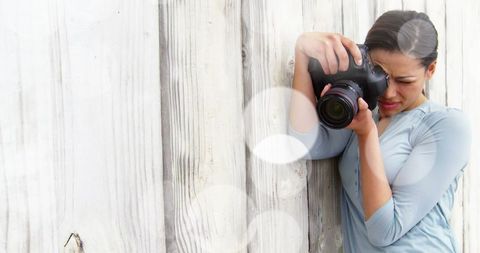 Female Photographer Checking Camera with Light Bokeh Filters