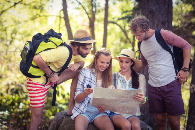 Group of friends looking at map in forest
