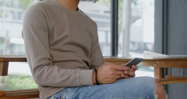 Man Relaxing Indoors Using Smartphone in Casual Outfit - Download Free Stock Images Pikwizard.com