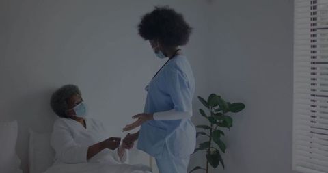 Nurse comforting hospital patient with gentle hand-hold