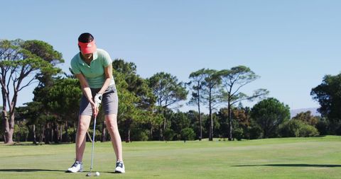 Female Golfer Focusing on Swing at Scenic Golf Course