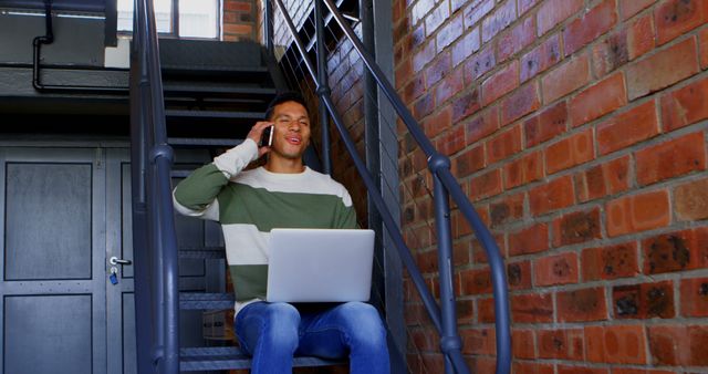 Young Man Working from Home on Laptop Talks on Phone Indoor Staircase - Download Free Stock Images Pikwizard.com