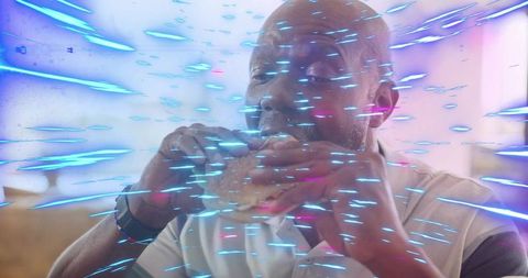 Senior man eating burger in diner with neon motion streaks, casual polo and wristwatch