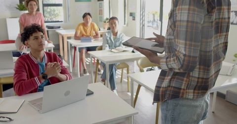 Instructor presenting with tablet to attentive students in interactive classroom lesson