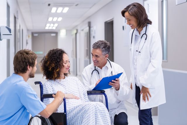Doctors interacting with pregnant woman in corridor - Download Free Stock Photos Pikwizard.com