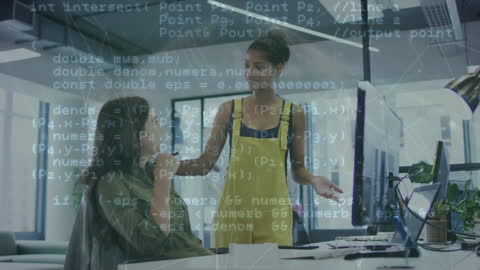 Two Women Discussing Computer Code in Modern Office Environment