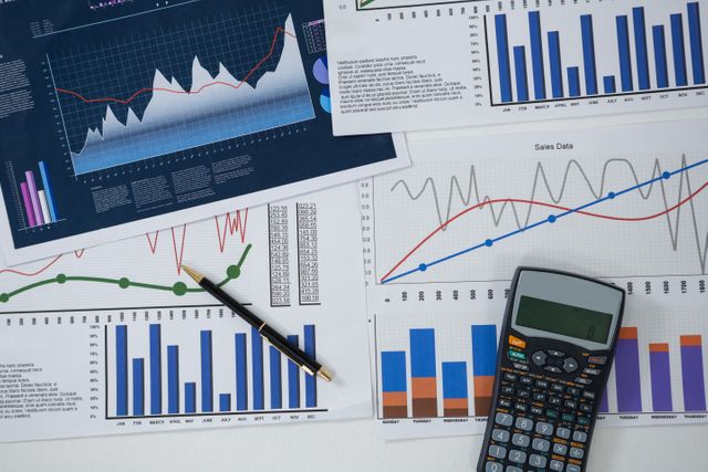 This image shows a close-up view of various financial graphs and charts, accompanied by a pen and a calculator. It is ideal for illustrating concepts related to financial analysis, business planning, economic reports, and market performance. Suitable for use in presentations, reports, articles, and educational materials focused on finance and business strategy.