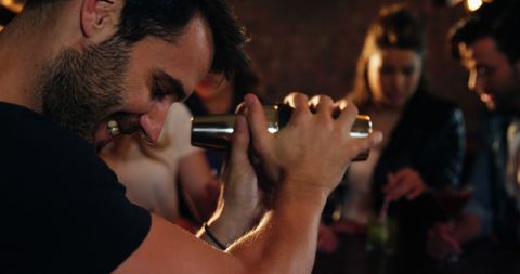 Skillful bartender shaking cocktail in lively bar atmosphere