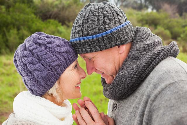 Digital composite of Close-up of senior couple in warm clothing touching heads